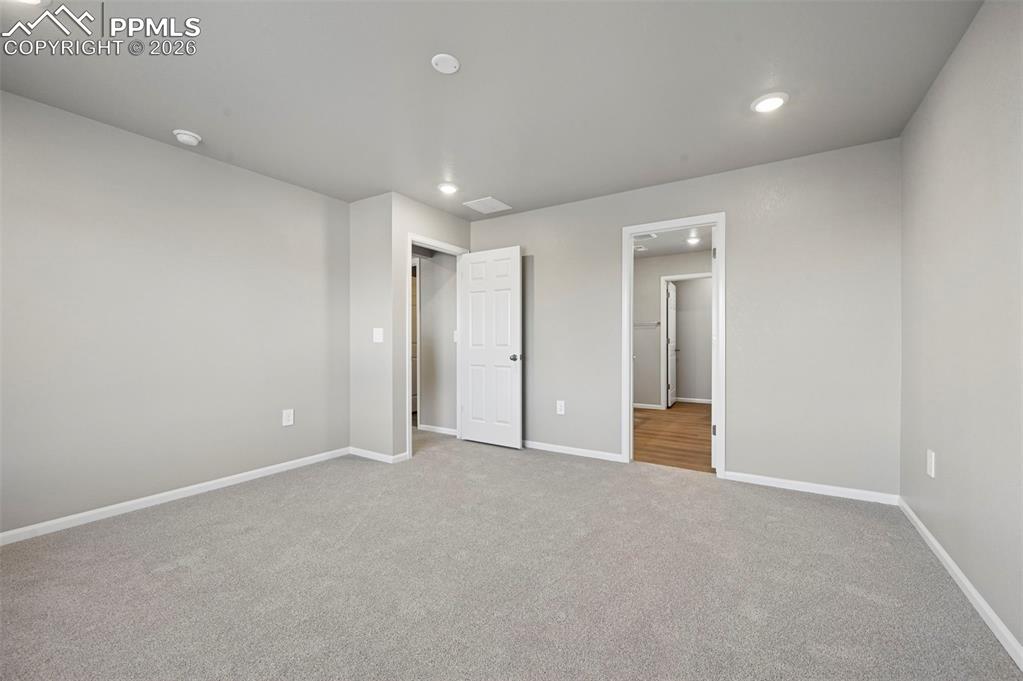 Image 19 of 39: Unstaged primary bedroom w/ ensuite 