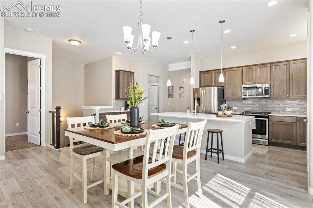 Image 7 of 46: Open concept kitchen & dining. Primary bdrm door on the left