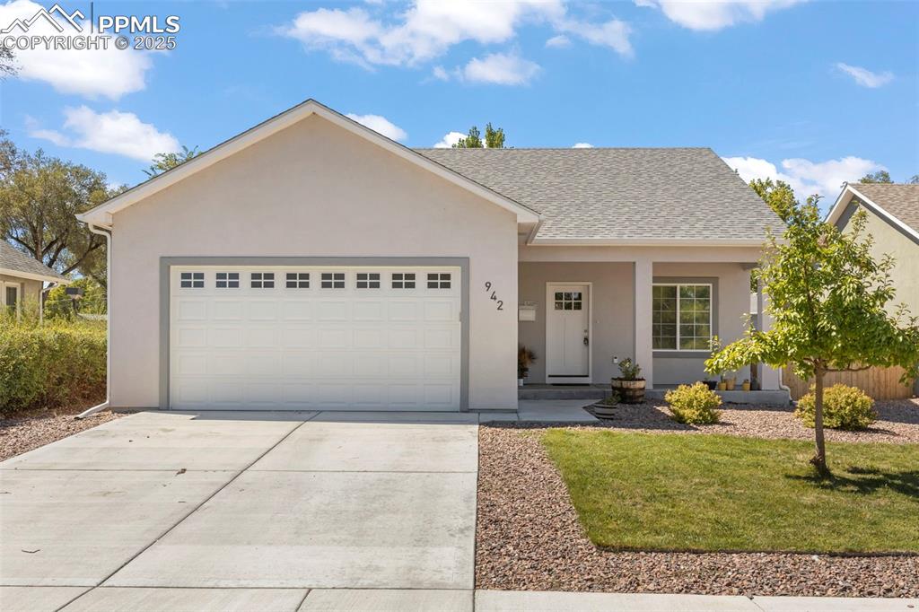 Caption: Ranch-style home featuring stucco siding, a shingled roof, an attached garage, and driveway