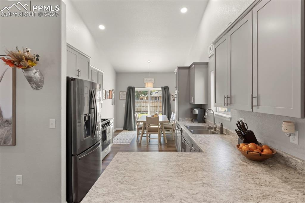 Image 10 of 23: Kitchen featuring stainless steel refrigerator with ice dispenser, gray cab