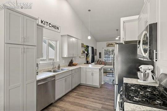 Image 11 of 23: Kitchen featuring appliances with stainless steel finishes, a peninsula, li