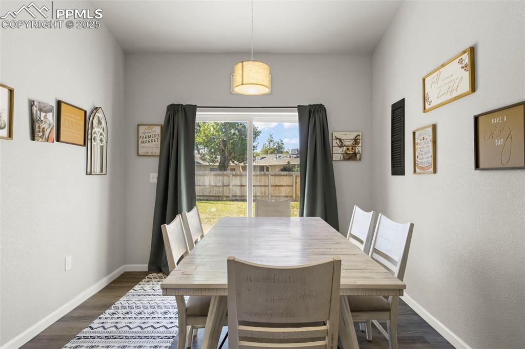 Image 12 of 23: Dining room featuring baseboards and dark wood-style floors