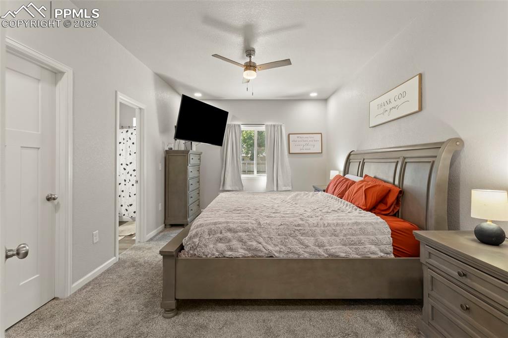 Image 14 of 23: Bedroom with carpet flooring, ceiling fan, and connected bathroom