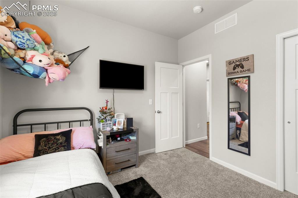 Image 21 of 23: Carpeted bedroom with baseboards