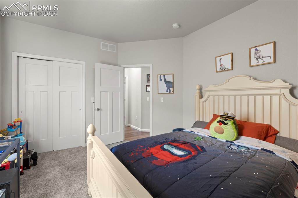 Image 22 of 23: Bedroom with a closet and light colored carpet