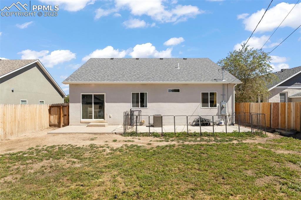 Image 3 of 23: Back of property with a patio, stucco siding, roof with shingles, and a fen