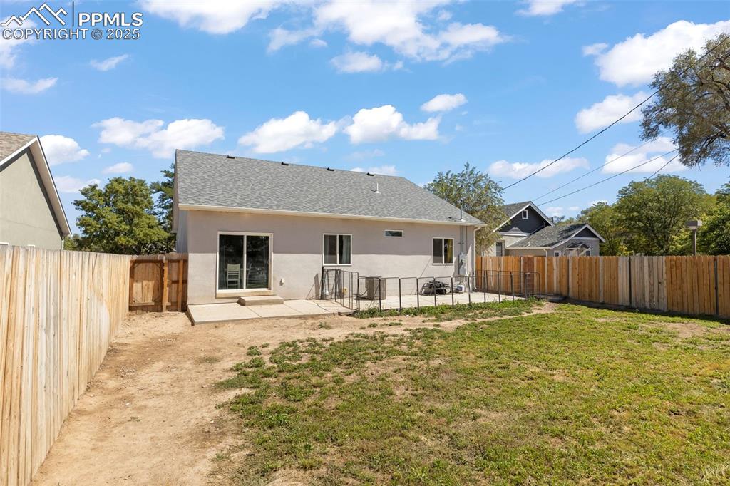 Image 4 of 23: Rear view of house with a patio area, stucco siding, a fenced backyard, and