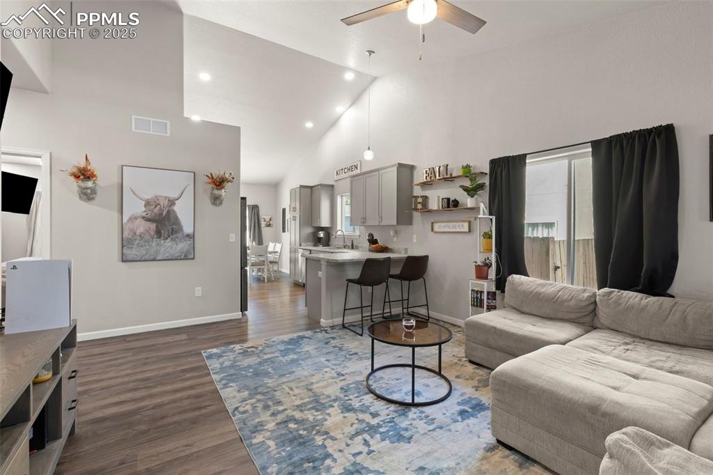 Image 6 of 23: Living area with high vaulted ceiling, dark wood-type flooring, recessed li