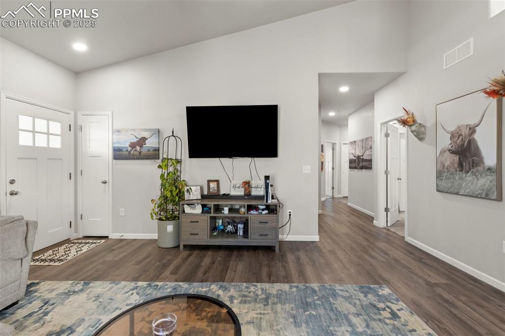 Image 8 of 23: Living room featuring dark wood-style flooring and recessed lighting