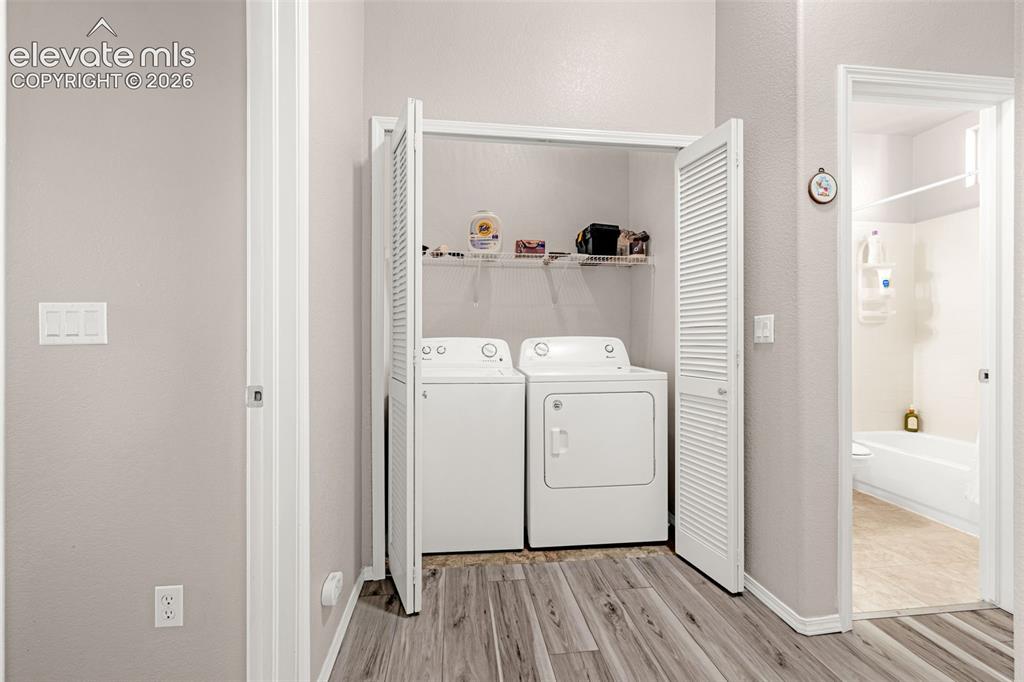 Image 13 of 27: Dedicated laundry area featuring bifold louvered closet doors, built-in wir