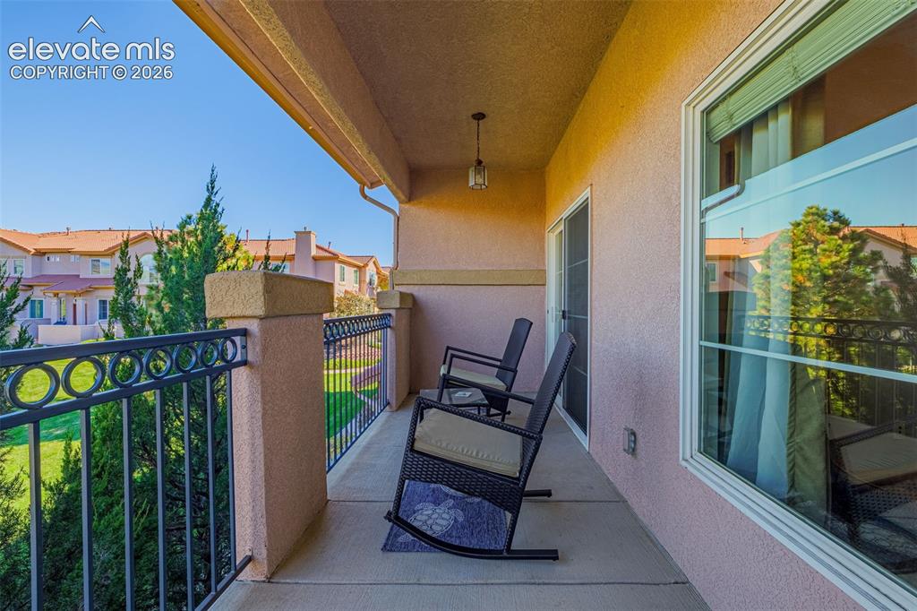 Image 22 of 27: Covered balcony featuring stucco-finished walls, a decorative metal railing