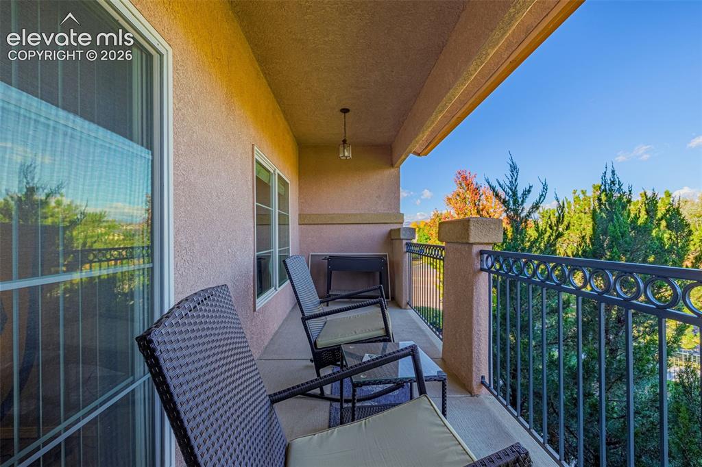Image 23 of 27: Covered balcony featuring a concrete floor, stucco finish, metal ornamental