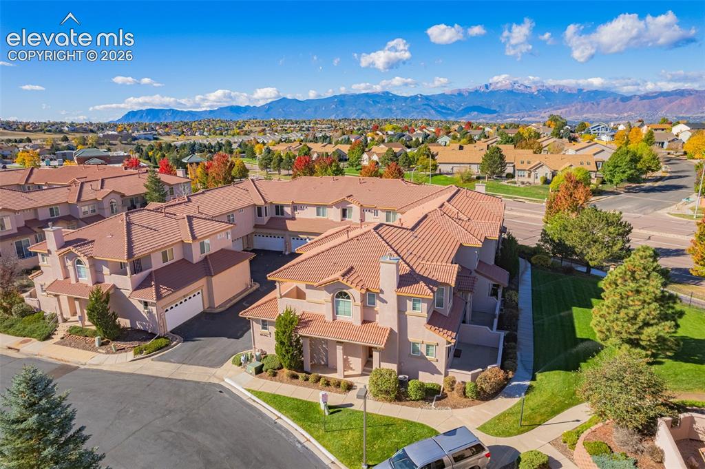 Image 25 of 27: Aerial perspective of multi-unit residential structures featuring stucco ex