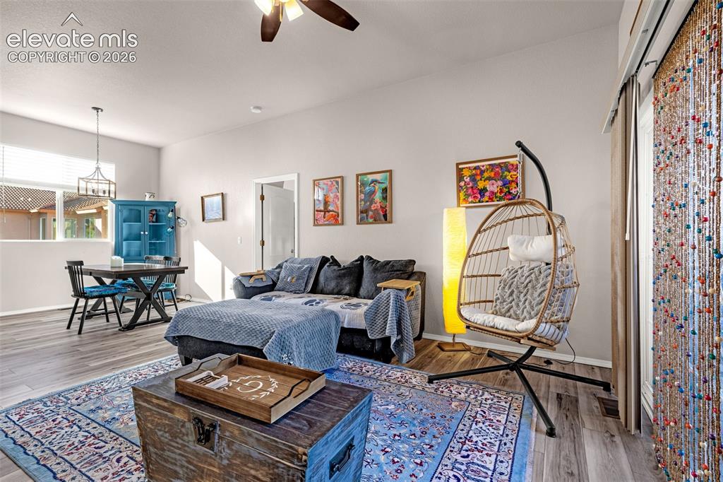 Image 9 of 27: Living space featuring high ceilings, wood-finish flooring, a ceiling fan w