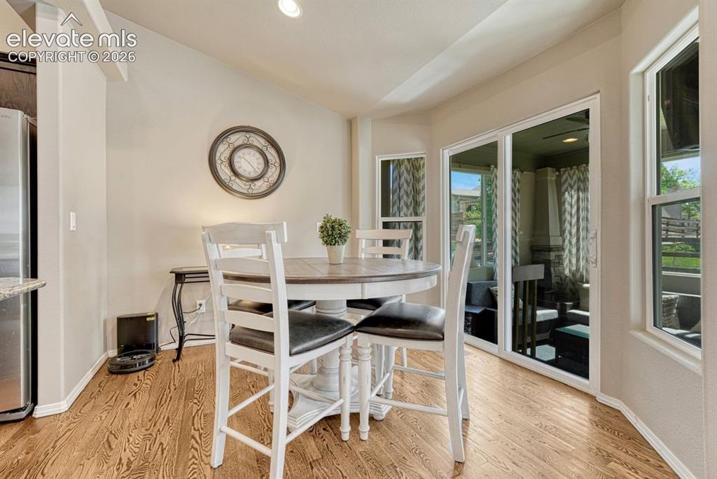 Image 20 of 50: Dining area with wood-finish flooring, vaulted ceiling, and recessed lighti