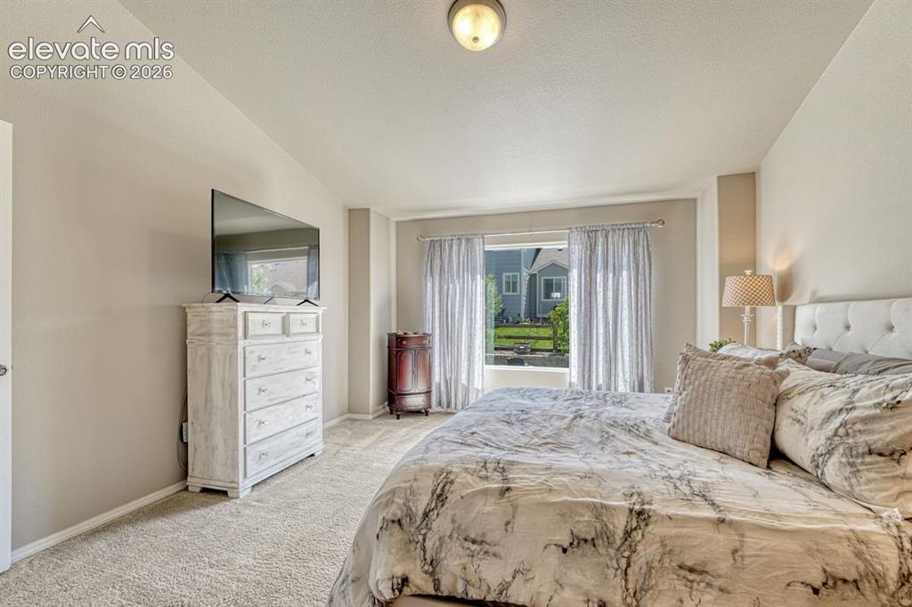 Image 24 of 50: Carpeted bedroom with neutral wall tones and carpet