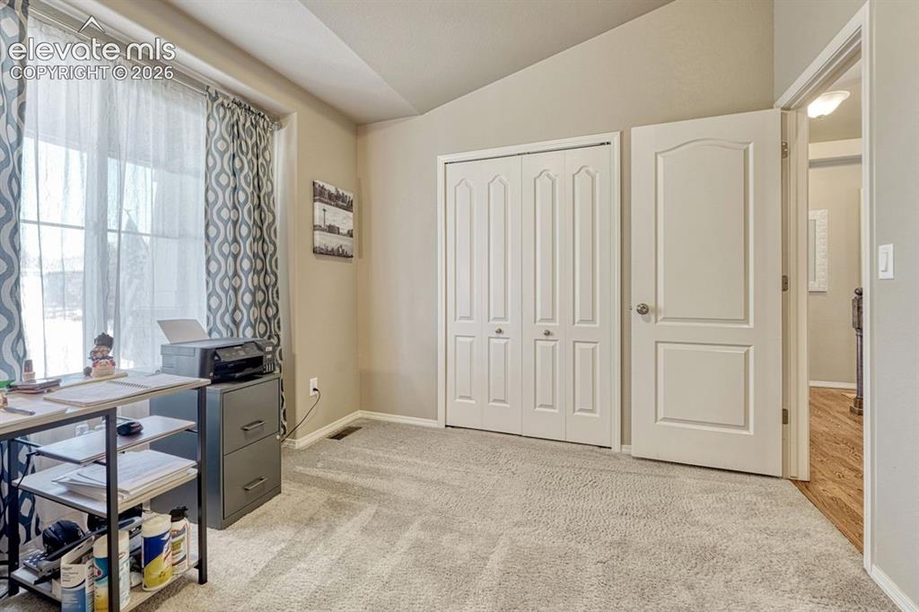 Image 29 of 50: Carpeted room featuring a large window, bi-fold closet doors, a paneled int
