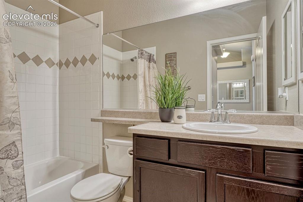 Image 30 of 50: Bathroom featuring a dark wood-finish vanity with a light-colored counterto