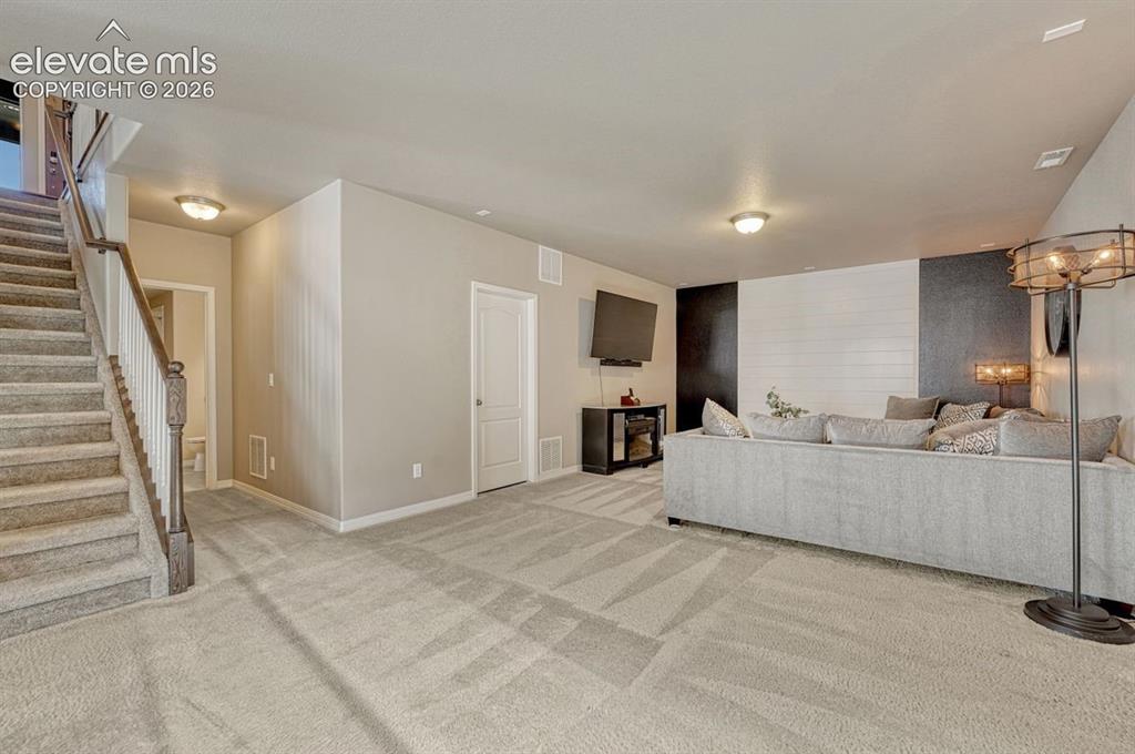 Image 31 of 50: Spacious lower-level area featuring plush patterned carpeting and neutral w