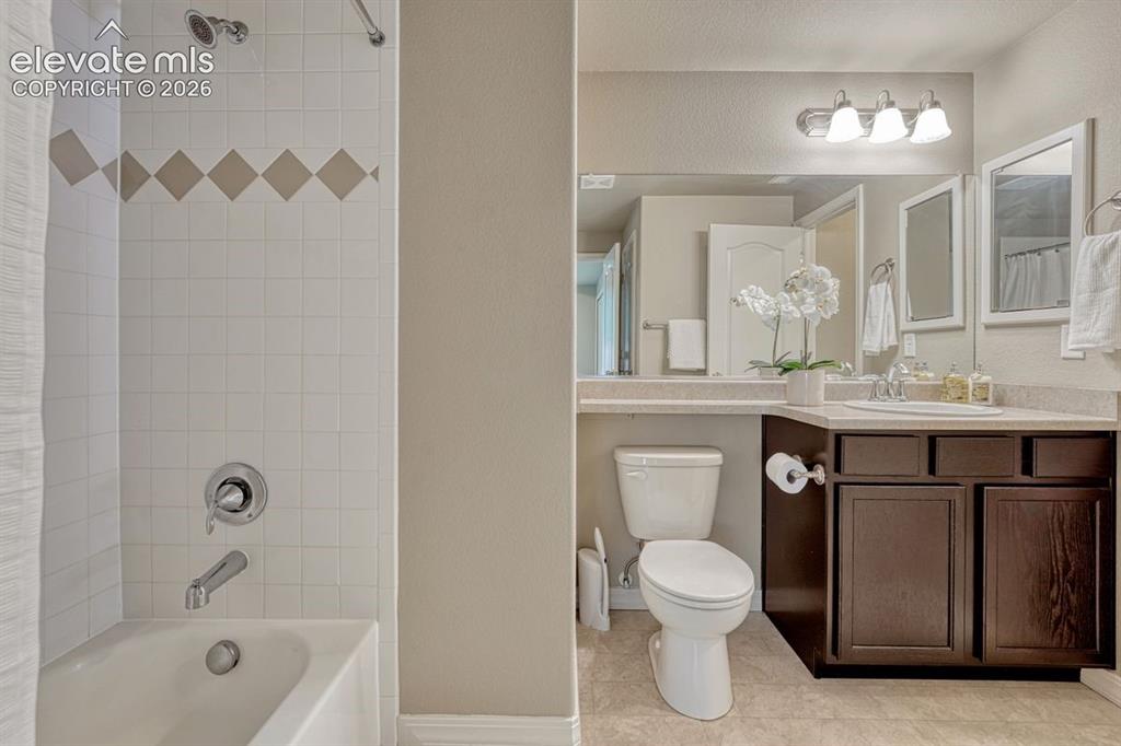 Image 39 of 50: Bathroom featuring a shower-tub combination with white square tile surround