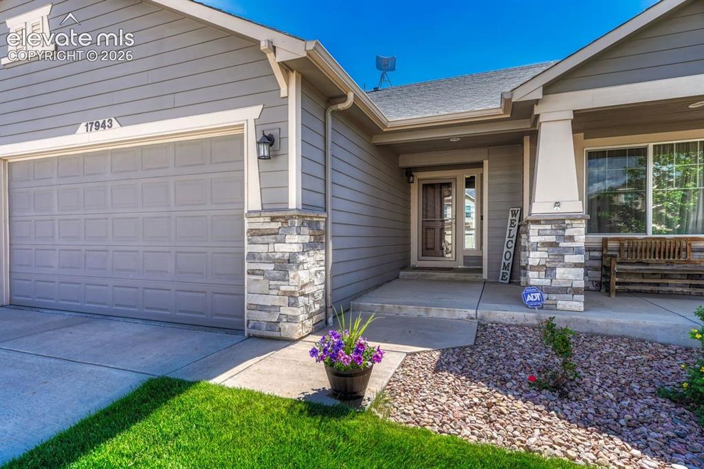 Image 9 of 50: Contemporary gray siding exterior with stone accent columns, an attached c-