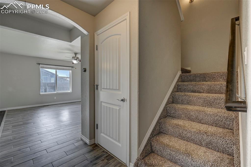 Image 11 of 50: Stairway with baseboards, ceiling fan, and wood finished floors