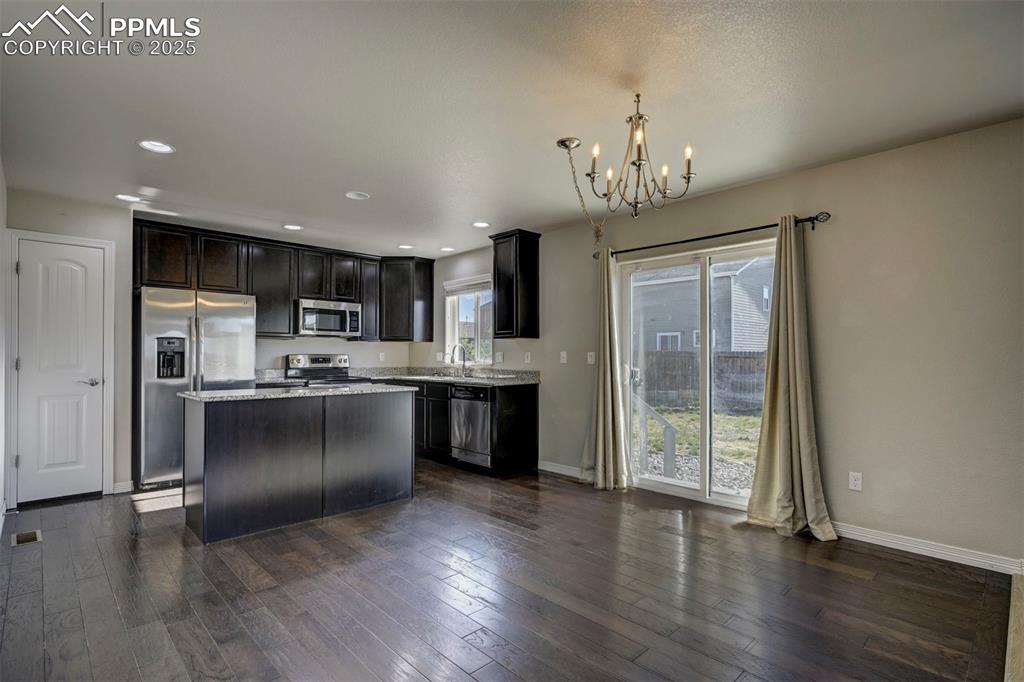 Image 17 of 50: Kitchen with an inviting chandelier, appliances with stainless steel finish