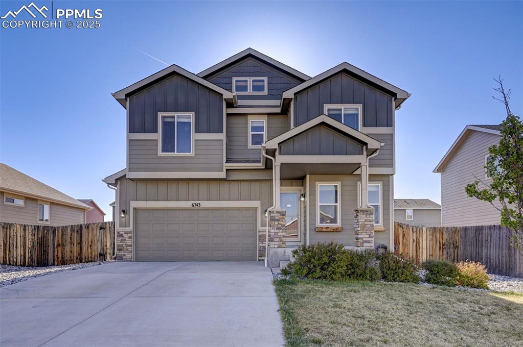 Image 2 of 50: Craftsman-style house featuring fence, board and batten siding, an attached