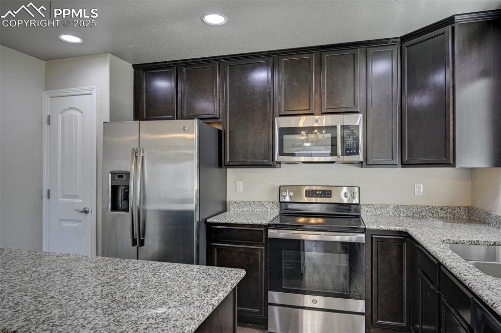 Image 20 of 50: Kitchen with appliances with stainless steel finishes, light stone countert