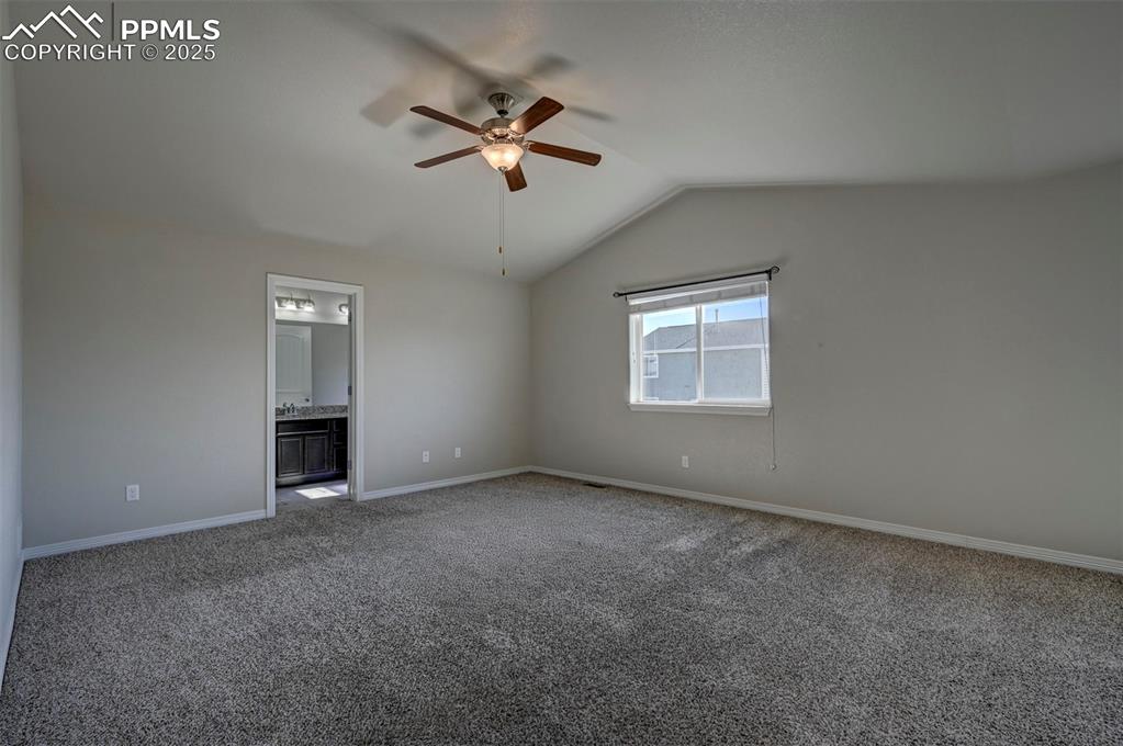 Image 22 of 50: Spare room with carpet flooring, ceiling fan, baseboards, and lofted ceilin