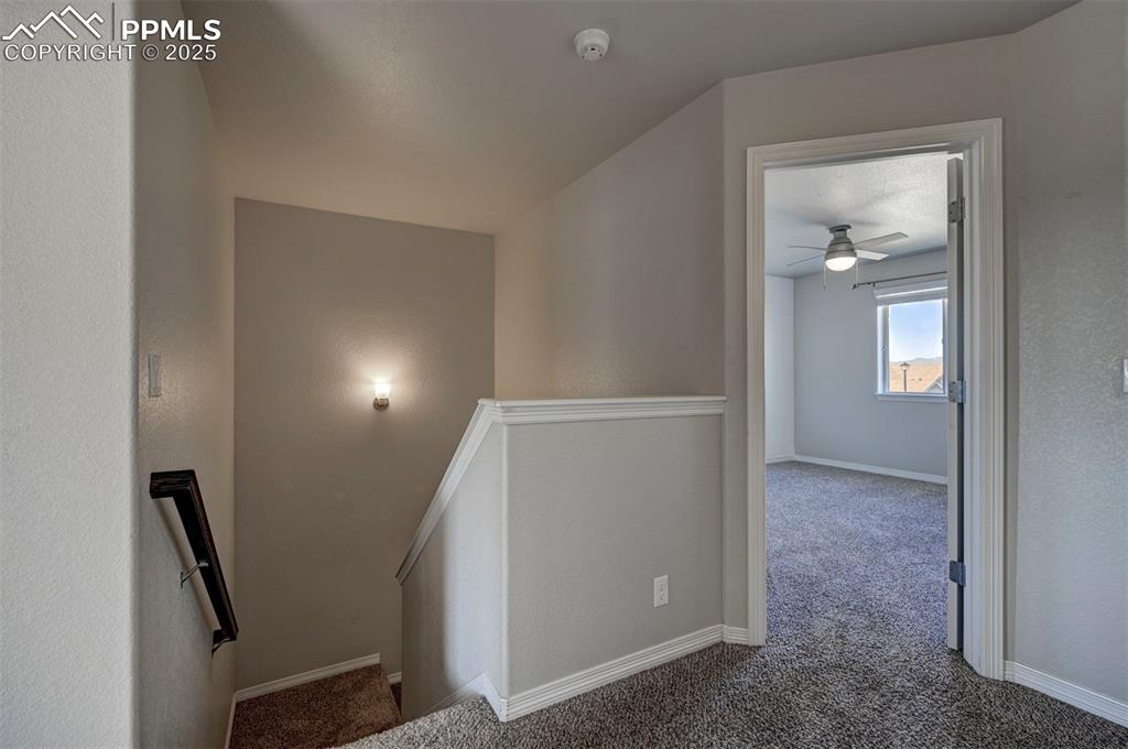 Image 23 of 50: Stairs with baseboards, a ceiling fan, and carpet flooring