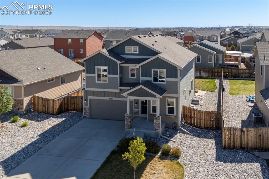 Image 4 of 50: View of front of home with a residential view, an attached garage, stone si