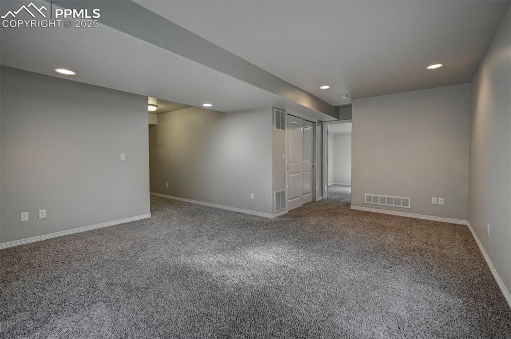 Image 41 of 50: Finished basement with carpet floors, recessed lighting, and visible vents
