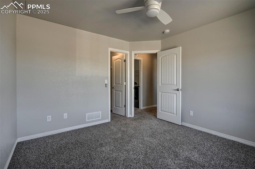 Image 46 of 50: Unfurnished bedroom featuring carpet floors, baseboards, a ceiling fan, and