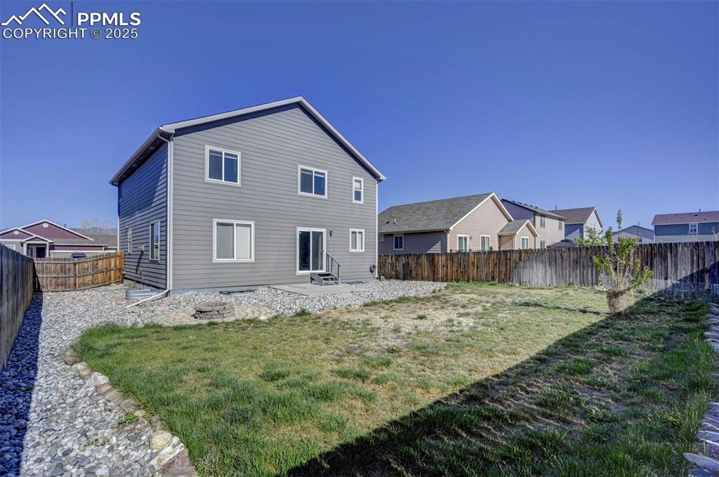 Image 47 of 50: Back of house with a yard, entry steps, a fenced backyard, and a patio area