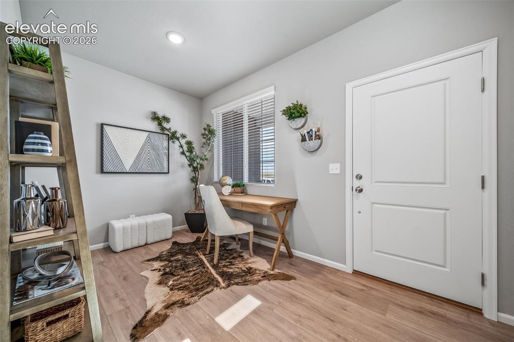 Image 10 of 21: Light wood-finish flooring complements soft gray walls in this versatile ro