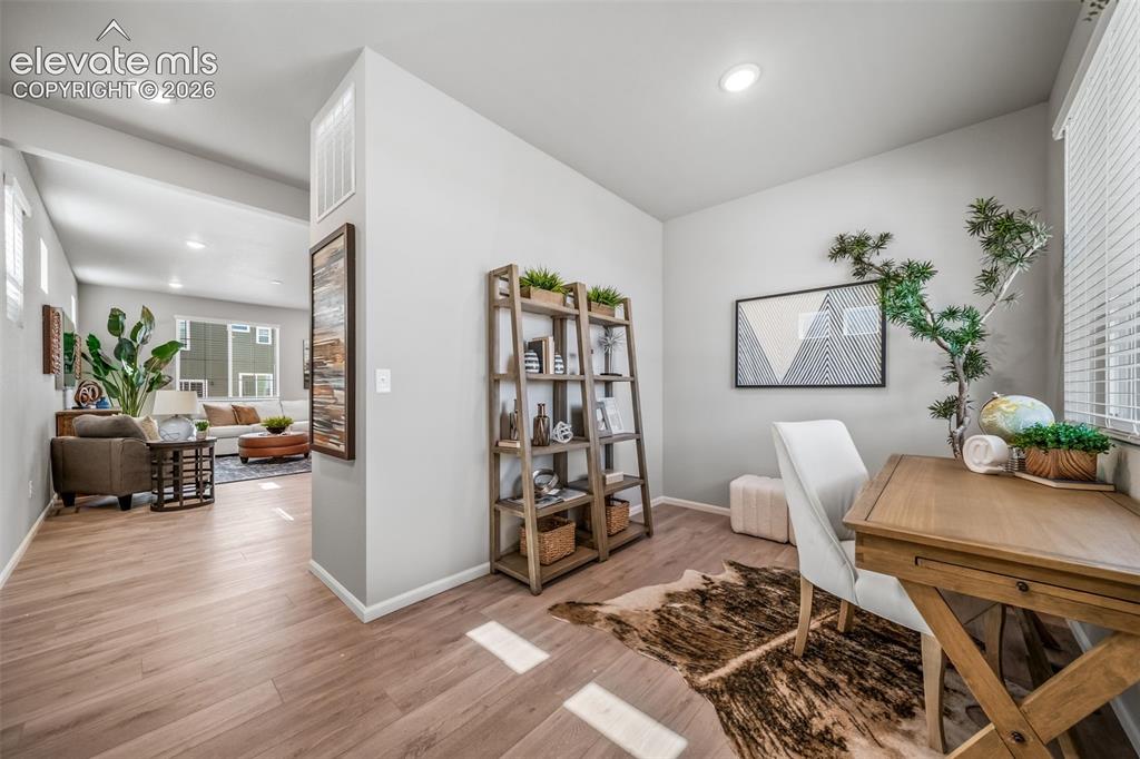 Image 13 of 21: Dedicated work area featuring wood-finish flooring, recessed lighting, and