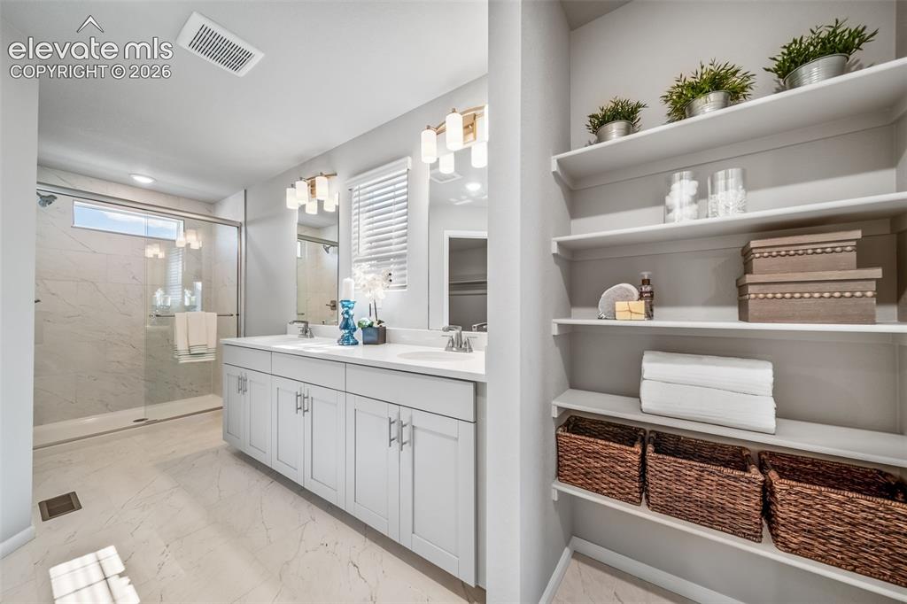 Image 18 of 21: Contemporary bathroom featuring a double vanity with light gray cabinetry,