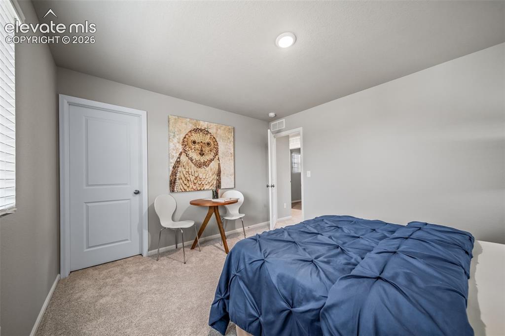 Image 2 of 21: Spacious room featuring neutral carpeting, a window with blinds, and light 
