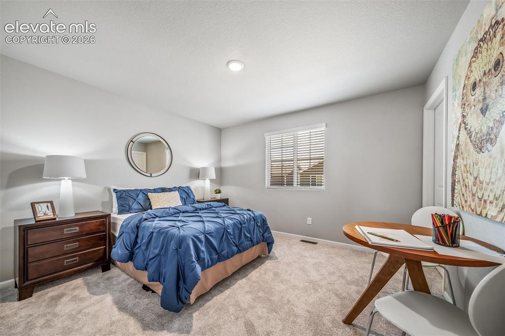 Image 3 of 21: Carpeted bedroom featuring light gray walls, a single window with blinds, a