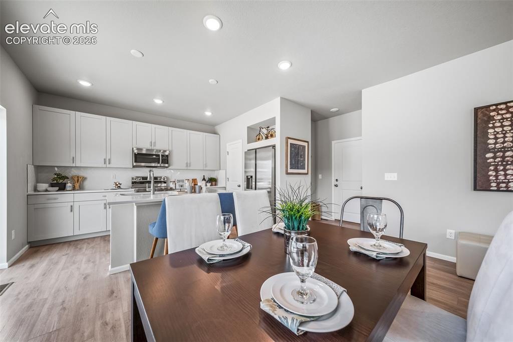Image 8 of 21: Open-concept dining area featuring wood-finish flooring, recessed lighting,