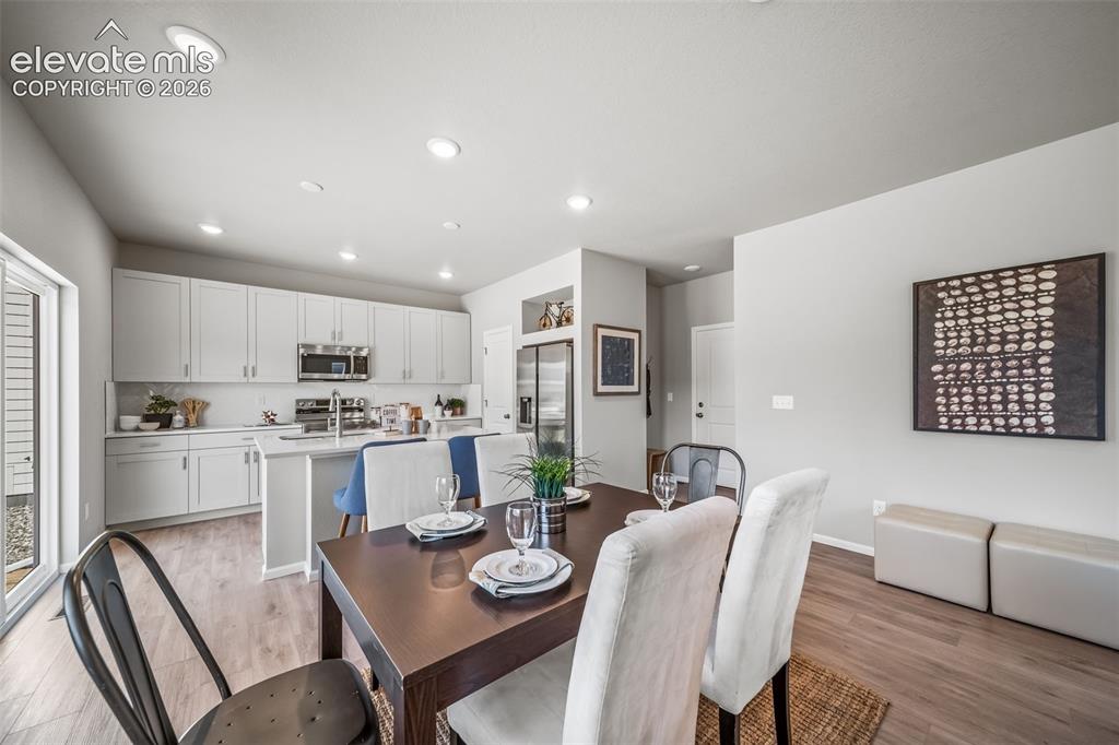 Image 9 of 21: Open-concept living area featuring wood-finish flooring and recessed lighti