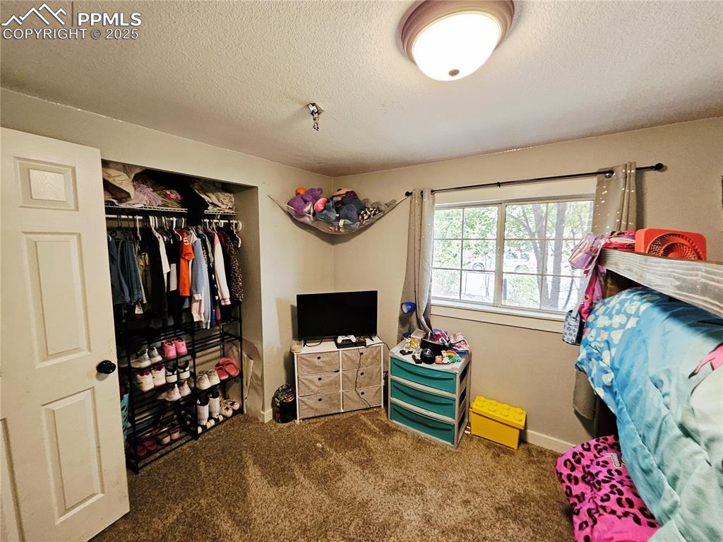 Image 15 of 23: Carpeted bedroom featuring a textured ceiling and a closet