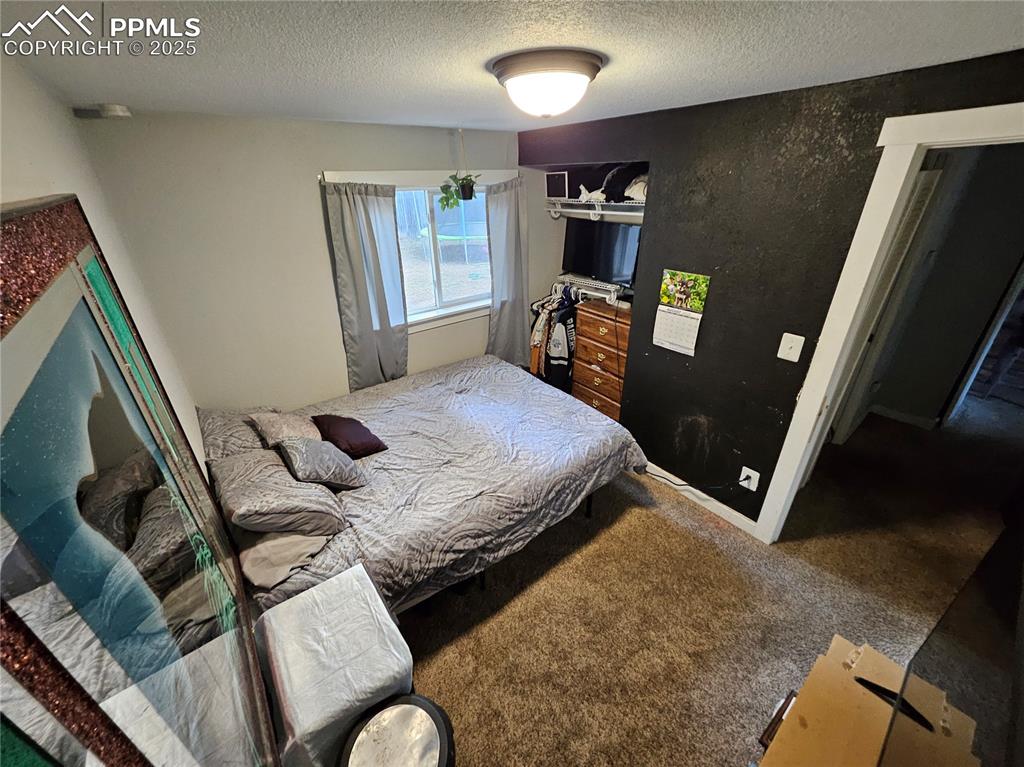 Image 17 of 23: Carpeted bedroom with a textured ceiling