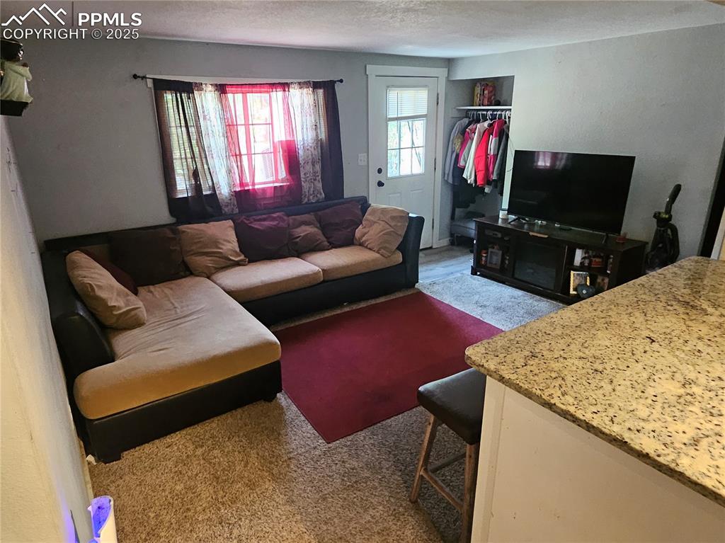 Image 6 of 23: Living area featuring a textured ceiling