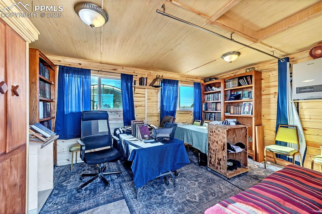 Image 14 of 44: Home office with wooden walls