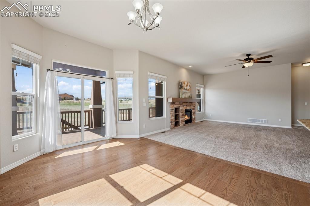 Image 10 of 38: Unfurnished living room featuring visible vents, a fireplace, wood finished