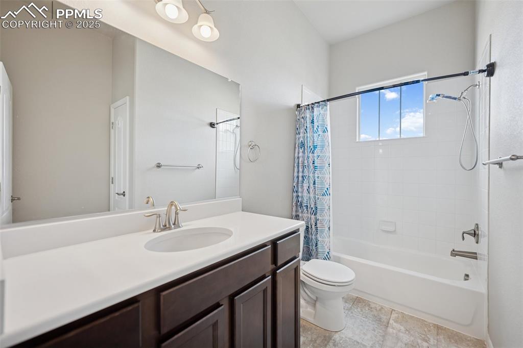 Image 16 of 38: Bathroom featuring vanity, toilet, and shower / tub combo with curtain