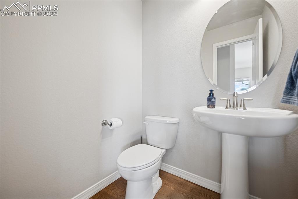 Image 17 of 38: Bathroom with a sink, baseboards, toilet, and wood finished floors