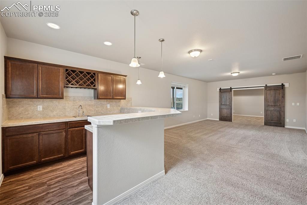 Image 22 of 38: Kitchen with visible vents, baseboards, light countertops, a sink, and back